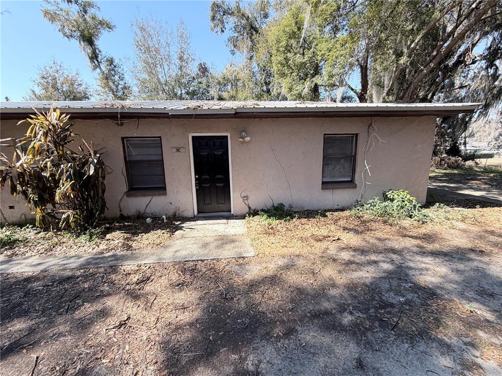 A single-story building with a black front door, two windows, and a metal roof — 670 GARDEN STREET, BARTOW, FL