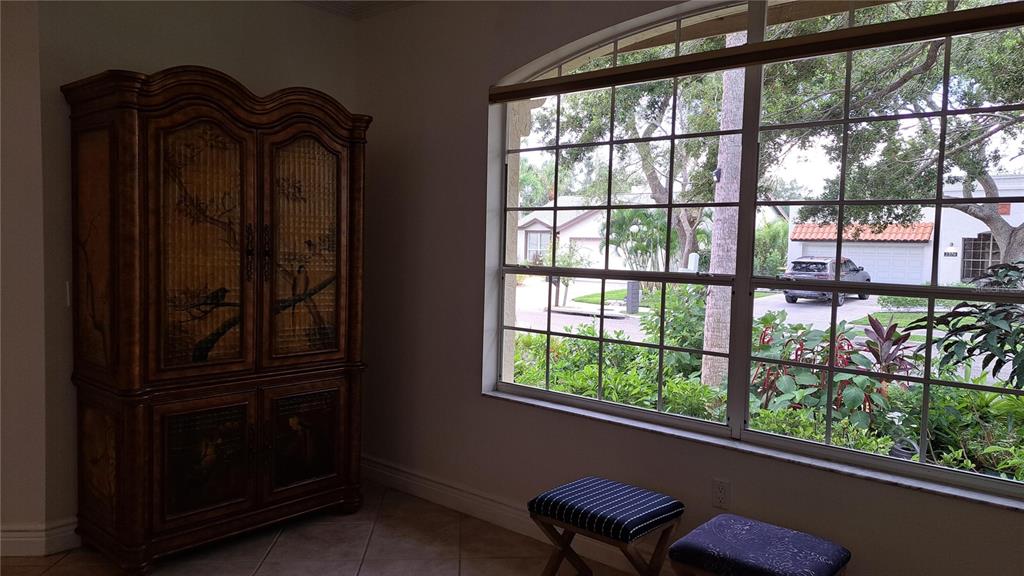 A living room features two dark leather sofas, an ottoman, and a framed boat painting — 2377 BURTON LANE, SARASOTA, FL
