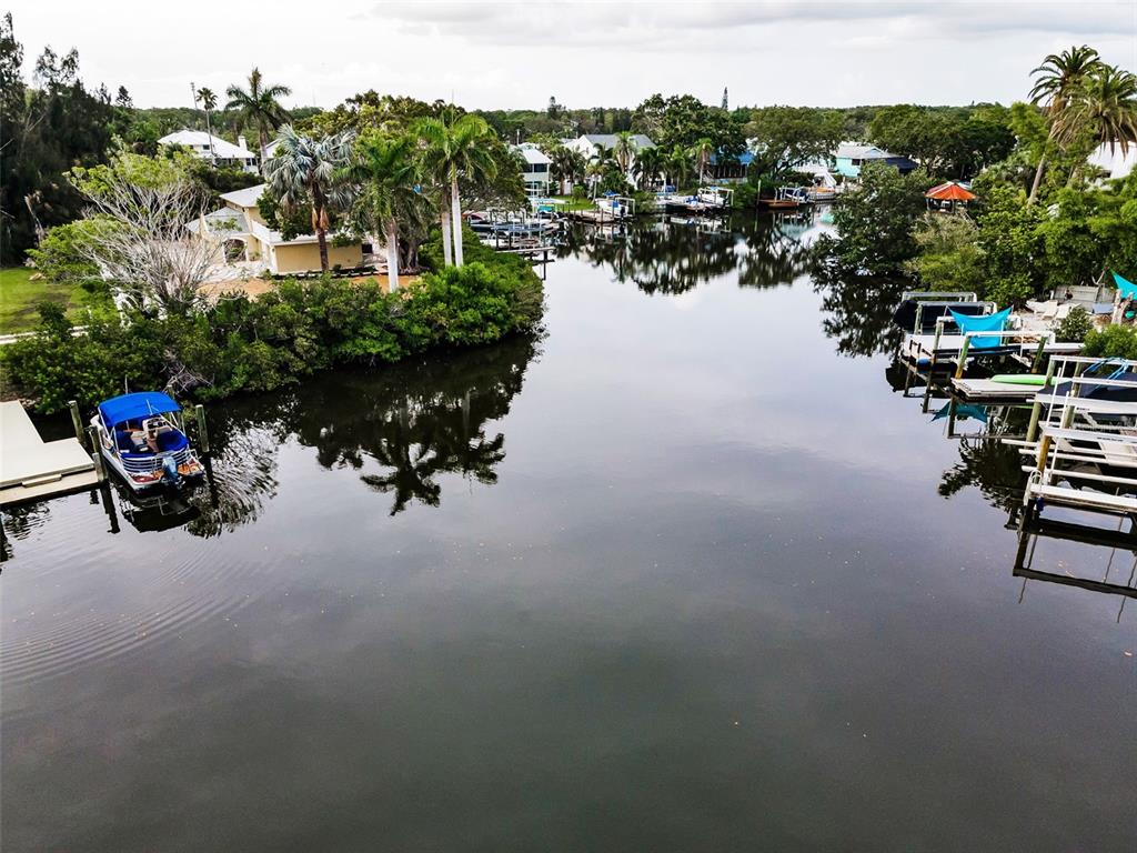 An aerial view of a canal lined with houses, boat docks, and lush tropical vegetation — 394 GEORGIA AVENUE, CRYSTAL BEACH, FL