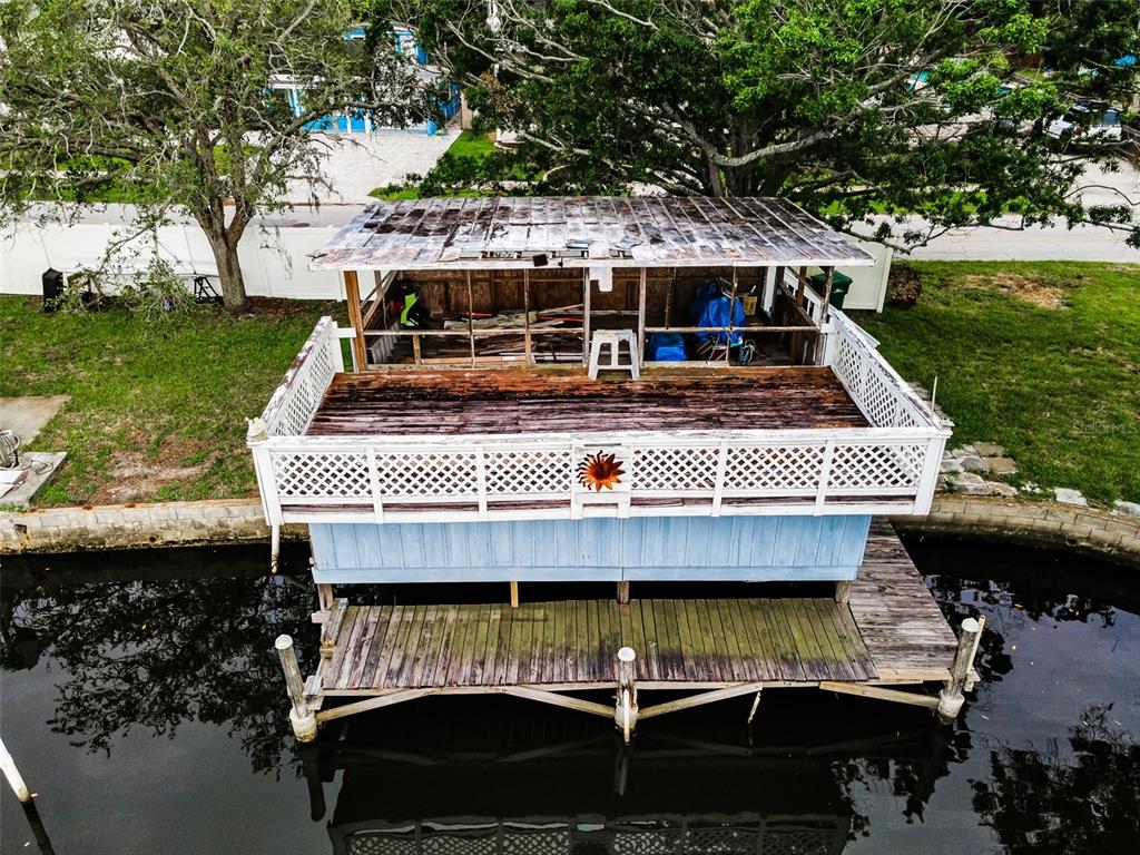 An elevated wooden boat dock with a weathered deck and a partially enclosed upper structure — 394 GEORGIA AVENUE, CRYSTAL BEACH, FL