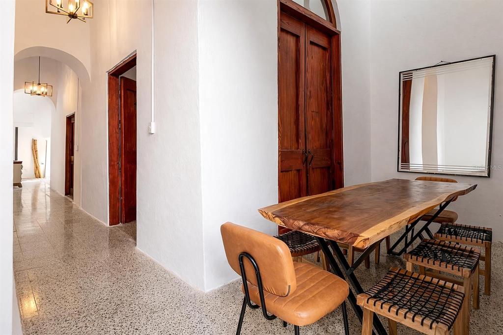 A dining area with a live-edge wooden table, leather chairs, and a mirror on white walls — 54 CALLE CRUZ UNIT 54, SAN JUAN, PR