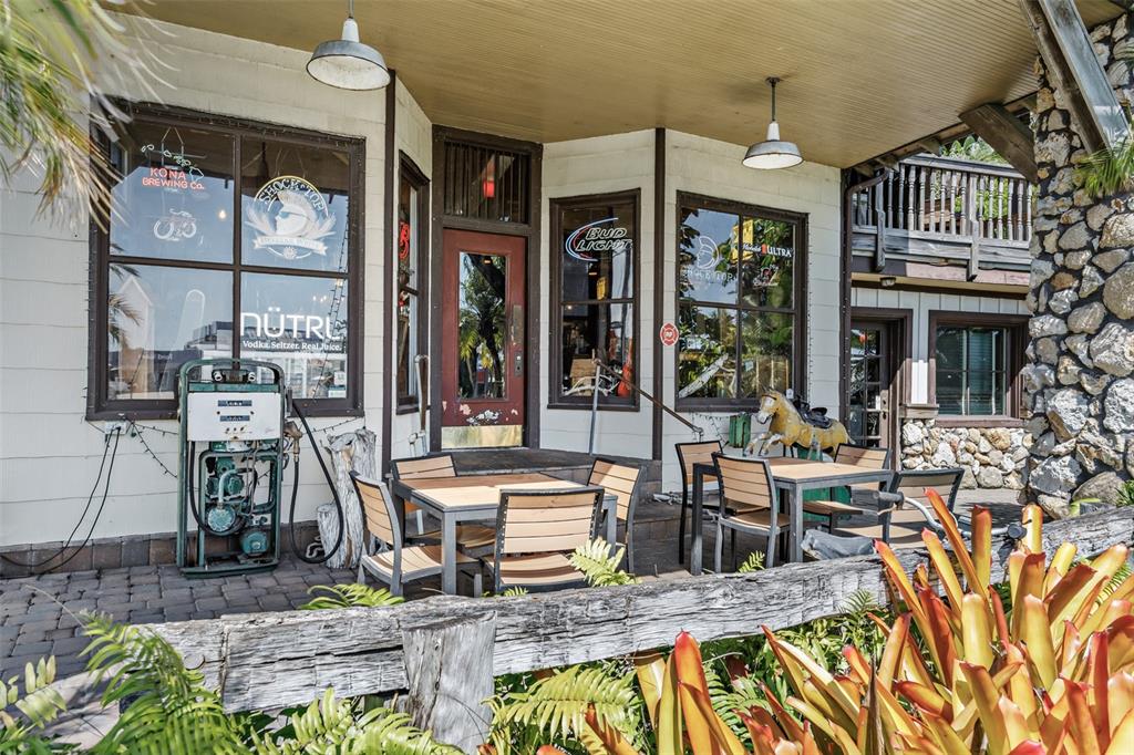 An outdoor patio area features tables, chairs, and a vintage gas pump near a building — 5390 HIGHWAY 1, GRANT VALKARIA, FL
