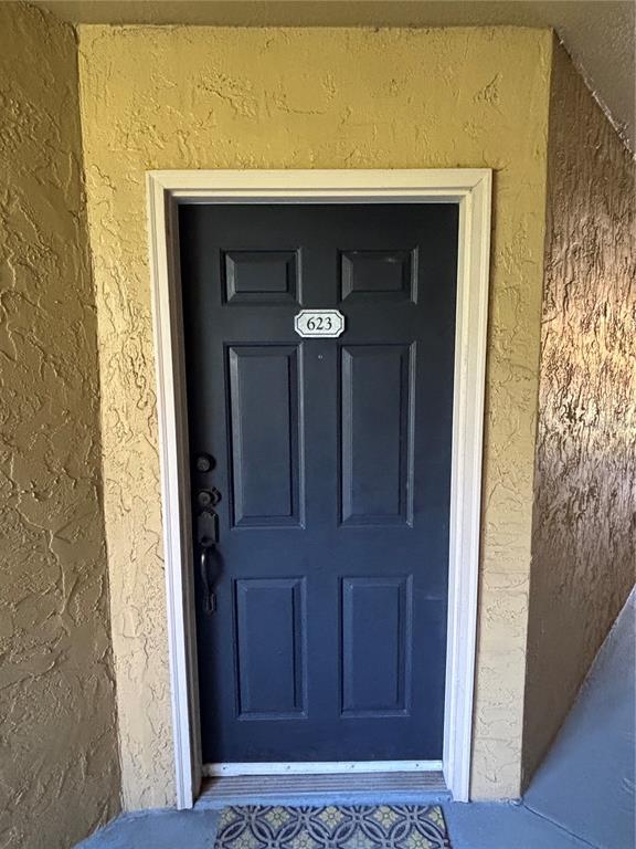 A dark blue front door with a number 623 plaque is set in a textured wall — 5124 CONROY ROAD UNIT 623, ORLANDO, FL