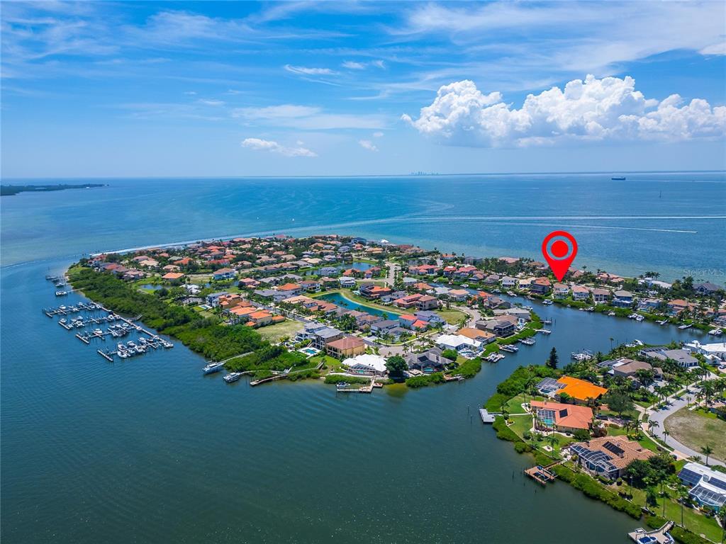 An aerial view shows a coastal residential community with homes, canals, and boat docks — 6203 MARBELLA BOULEVARD, APOLLO BEACH, FL