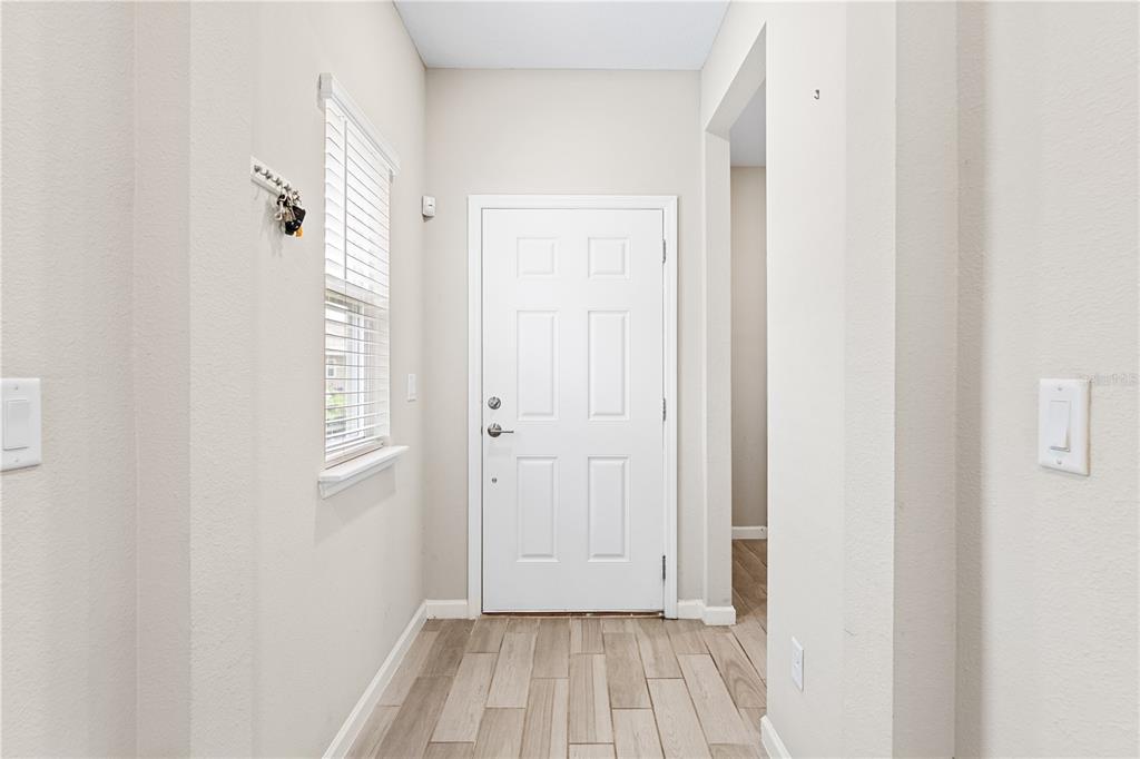 A bright entryway features a white front door, light wood-look tile flooring, and neutral walls — 507 TYNES BOULEVARD, MIDDLEBURG, FL