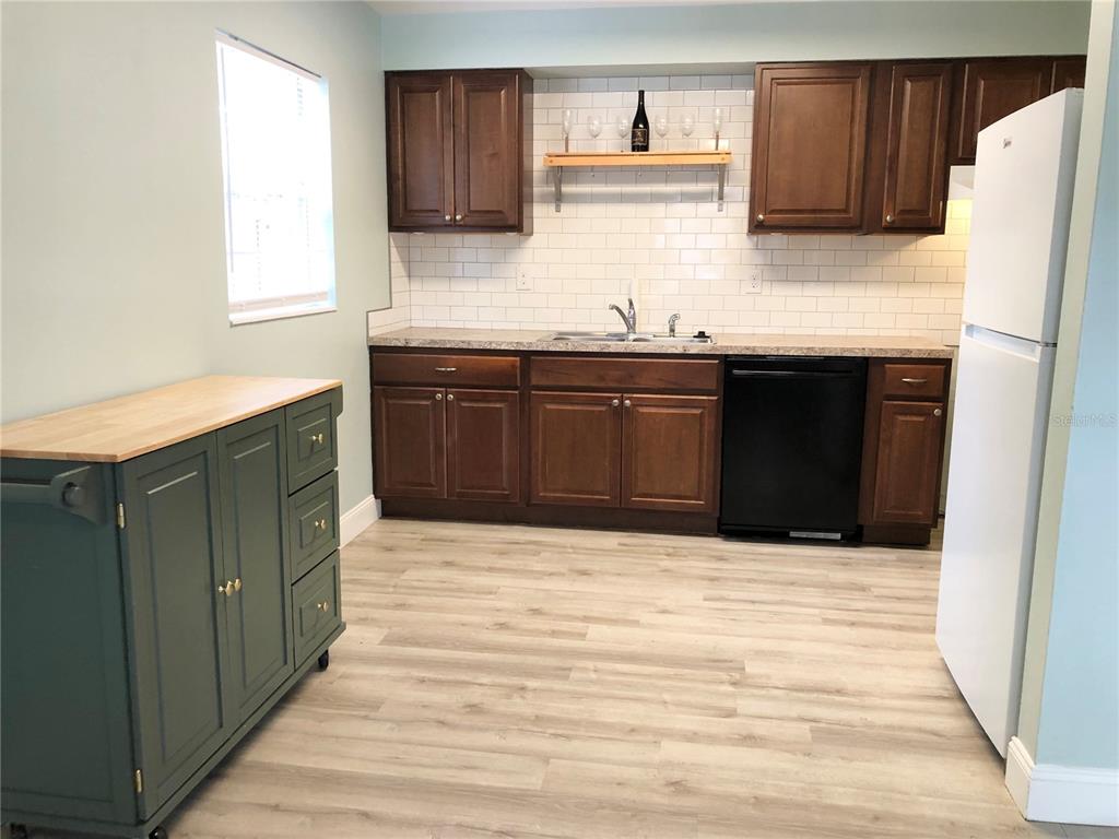 A kitchen features dark wood cabinets, a white subway tile backsplash, and a green island — 415 W EASY STREET, BARTOW, FL