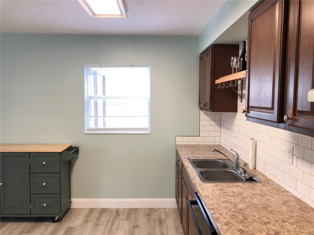 A kitchen features dark wood cabinets, a subway tile backsplash, and a rolling green island — 415 W EASY STREET, BARTOW, FL