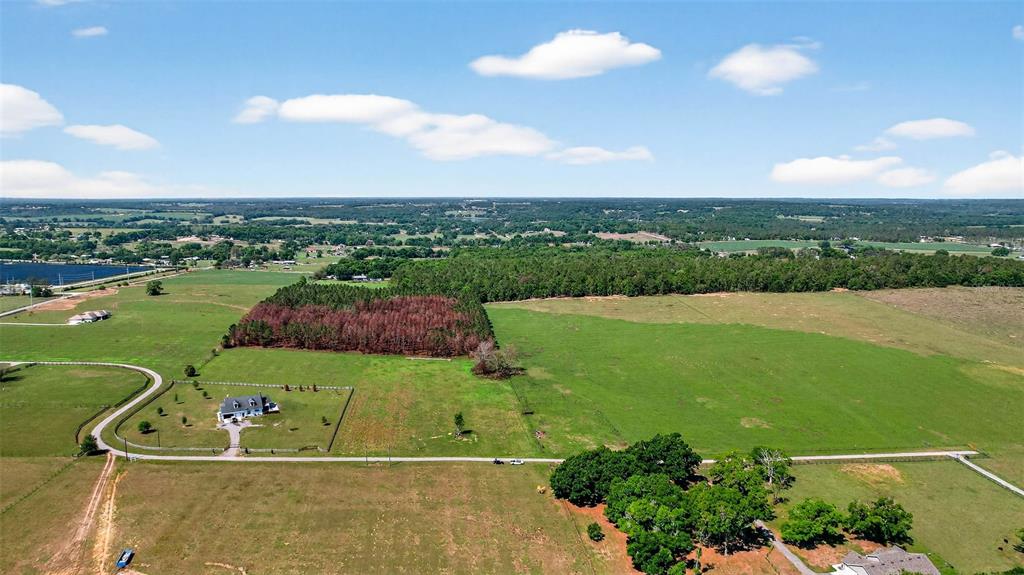 An aerial view shows a rural property with a house, pastures, and wooded areas — 0 HILLTOP HORIZONS PLACE, DADE CITY, FL