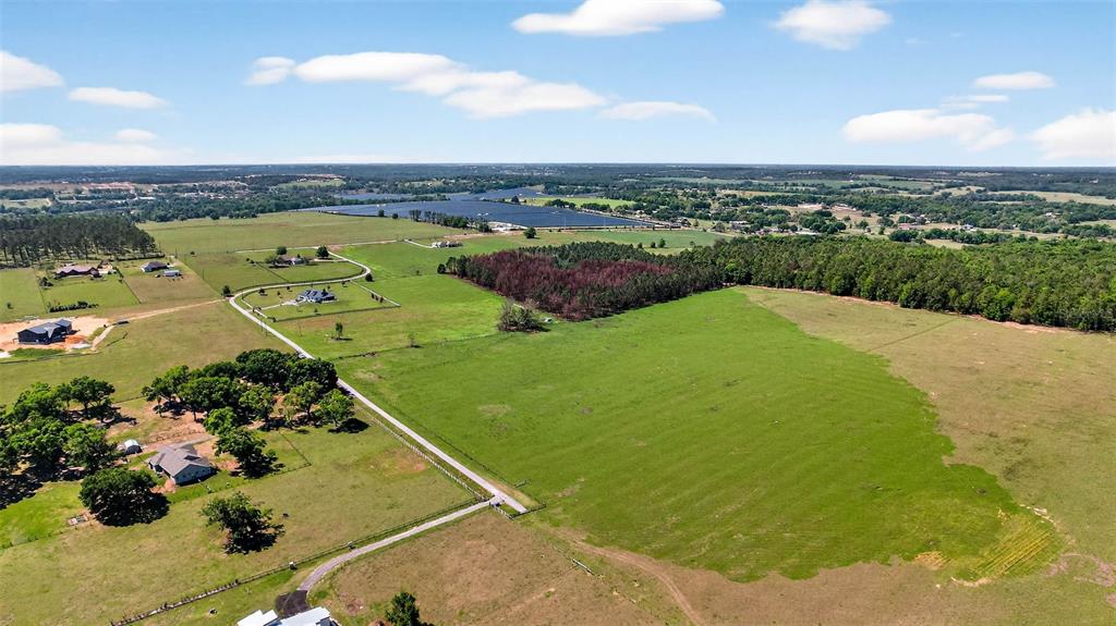 An aerial view shows a large rural property with green pastures, wooded areas, and houses — 0 HILLTOP HORIZONS PLACE, DADE CITY, FL