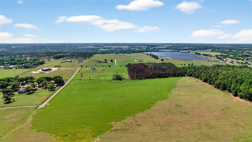 An aerial view shows a large green pasture with scattered trees and nearby residential homes — 0 HILLTOP HORIZONS PLACE, DADE CITY, FL