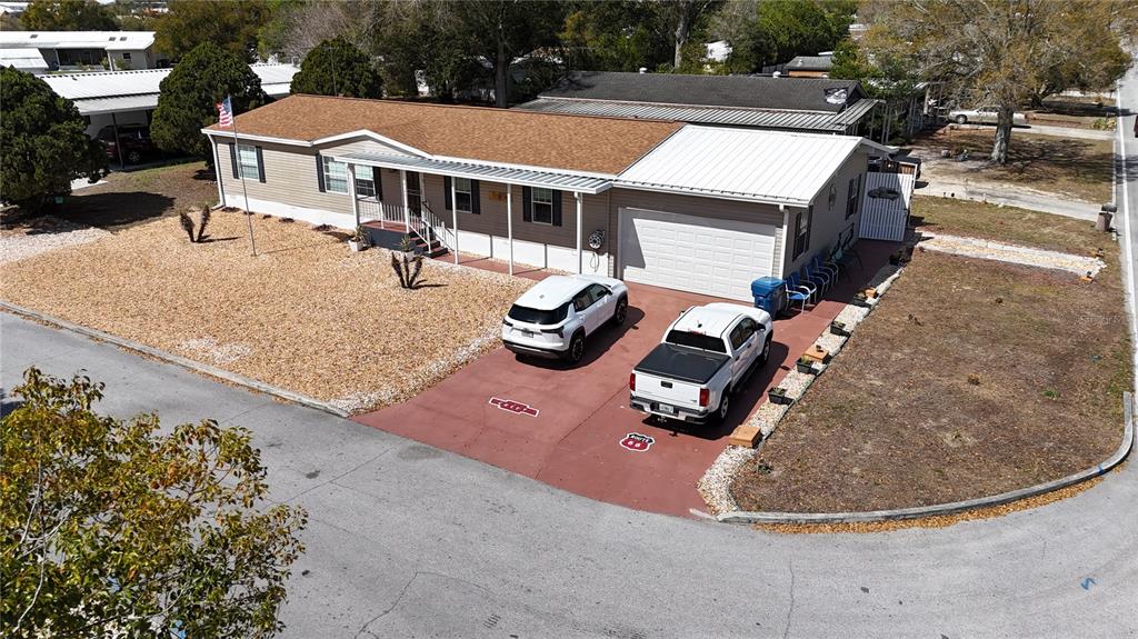 An aerial view shows a single-story house with a tan exterior, metal roof, and driveway — 8144 WEATHERFORD AVENUE, BROOKSVILLE, FL