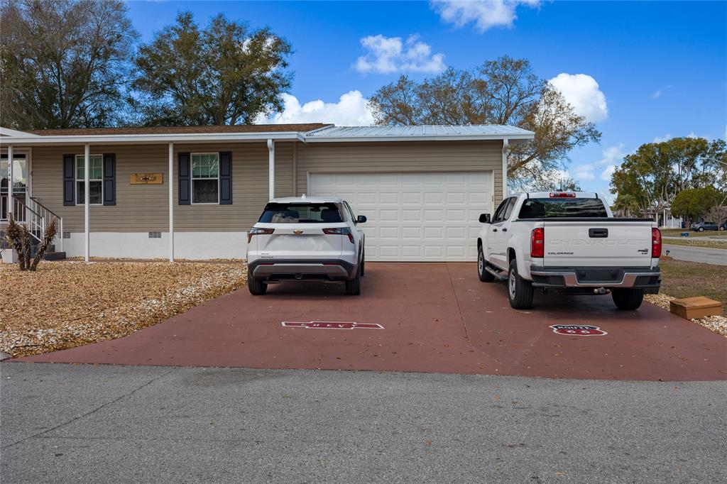 A house exterior features a two-car driveway with two white vehicles parked in front — 8144 WEATHERFORD AVENUE, BROOKSVILLE, FL