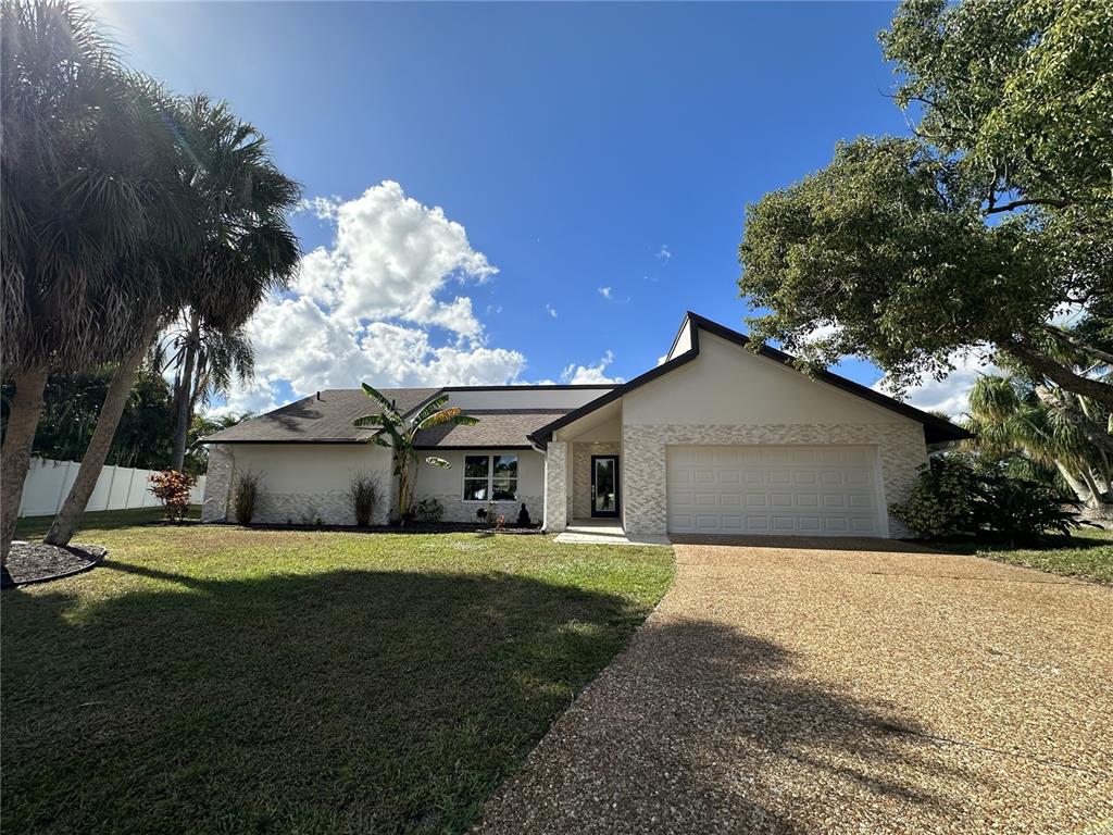 A single-story house with a stone facade, a two-car garage, and a gravel driveway — 4723 THOMAS HOBY PLACE, SARASOTA, FL