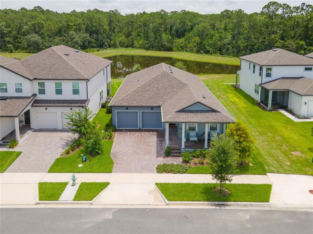 An aerial view shows a single-story house with a two-car garage and a pond behind — 11243 PIXIE MANDARIN COURT, WINTER GARDEN, FL