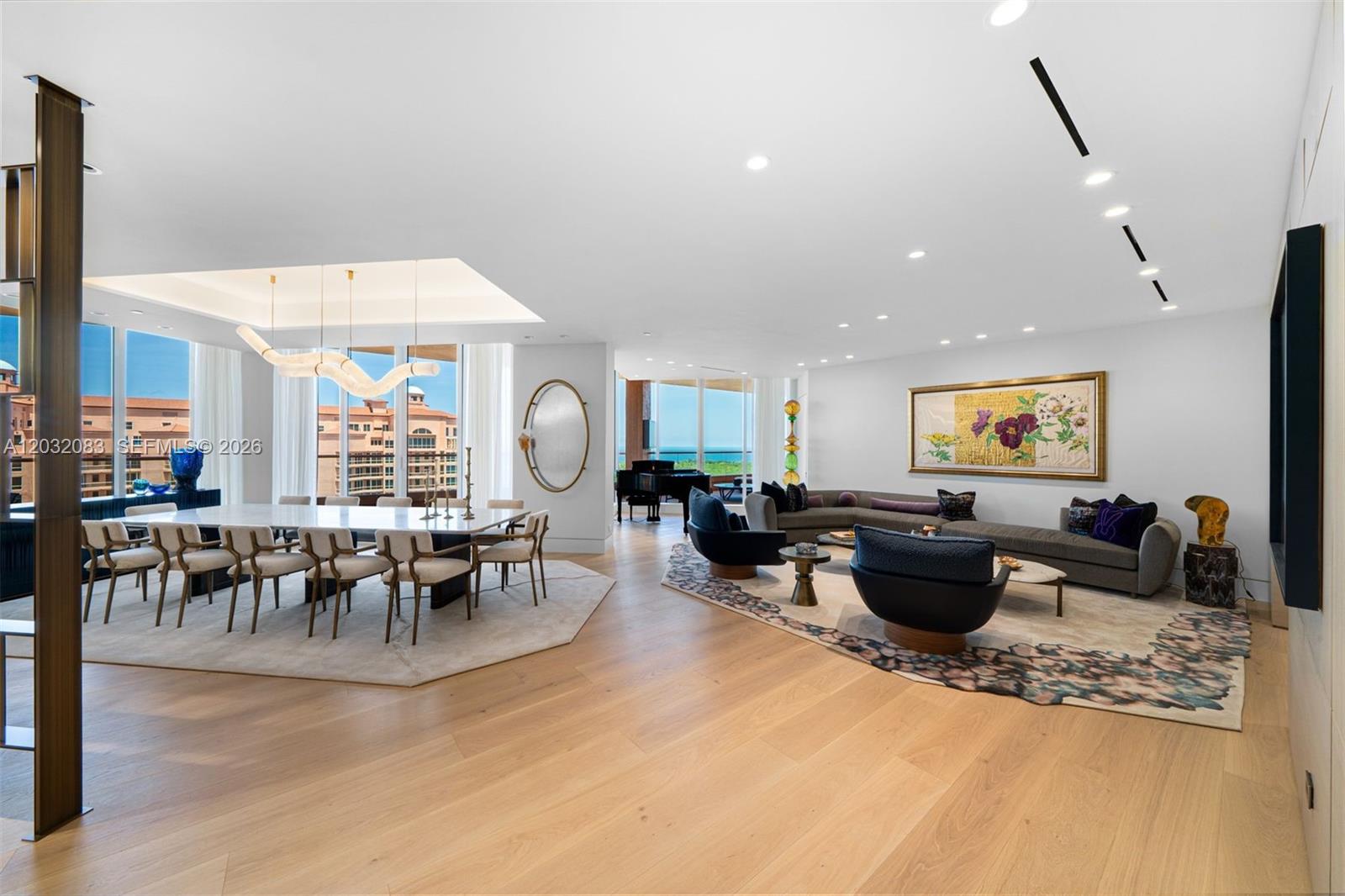 A spacious open-concept living and dining area features hardwood floors, floor-to-ceiling windows, and modern decor — 60 Edgewater Dr # D, Coral Gables FL 33133, CORAL GABLES, FL