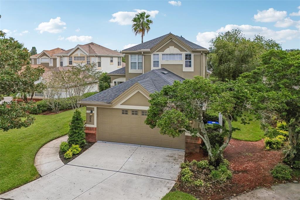 An aerial view shows a two-story suburban house with a garage and a paved driveway — 3050 SHOAL CREEK VILLAGE DRIVE, LAKELAND, FL