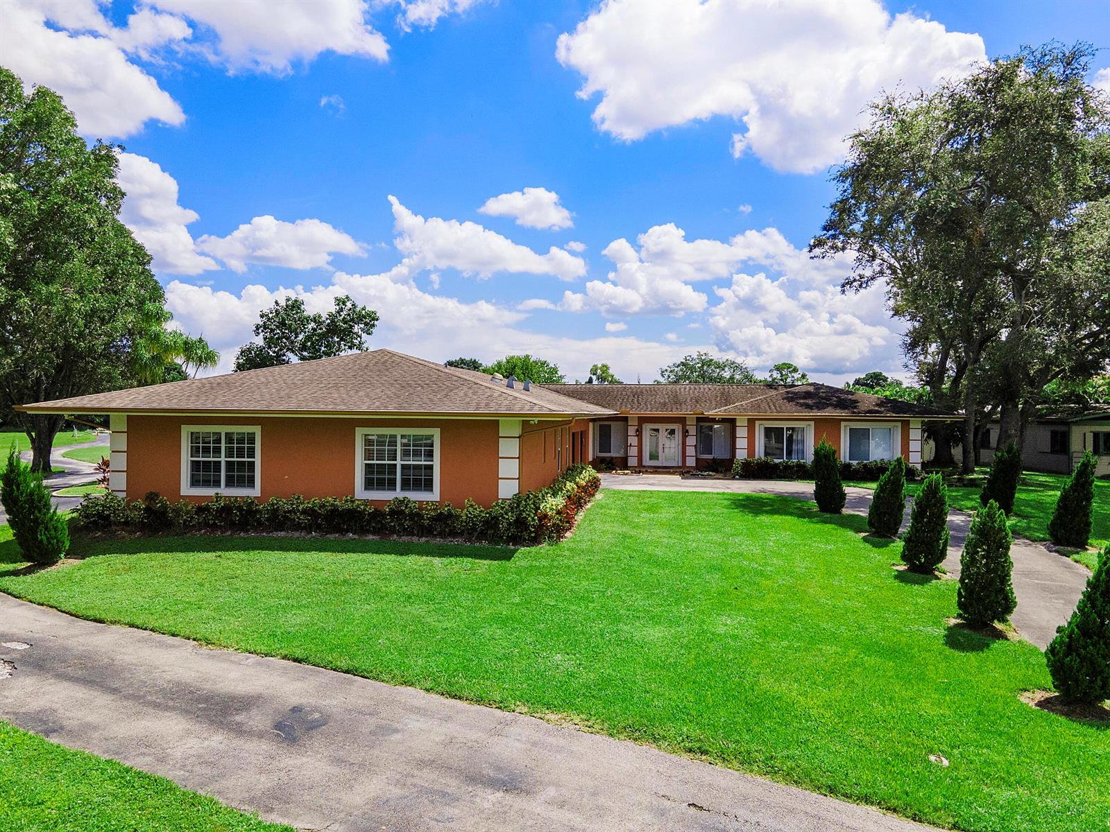 A single-story house with an orange exterior, white trim, and a large front lawn — 7600 NW 82nd Terrace, Parkland FL 33067, PARKLAND, FL