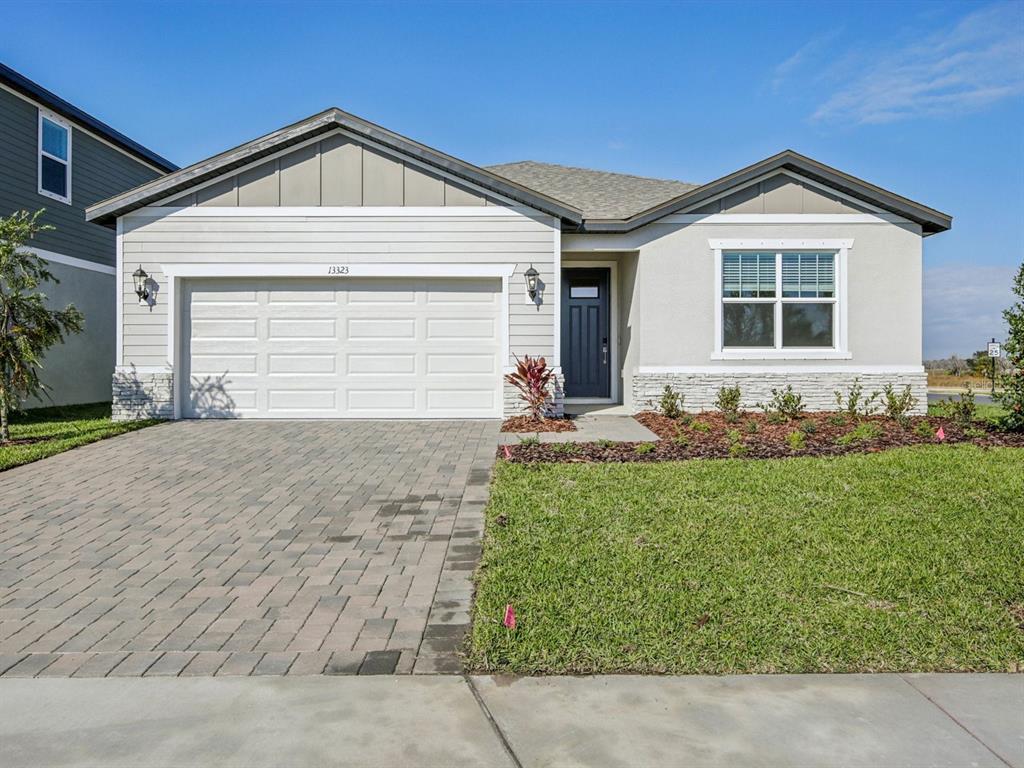 A single-story house with a paved driveway, a two-car garage, and a stone facade — 13323 SHELLMORE AVENUE, PALMETTO, FL