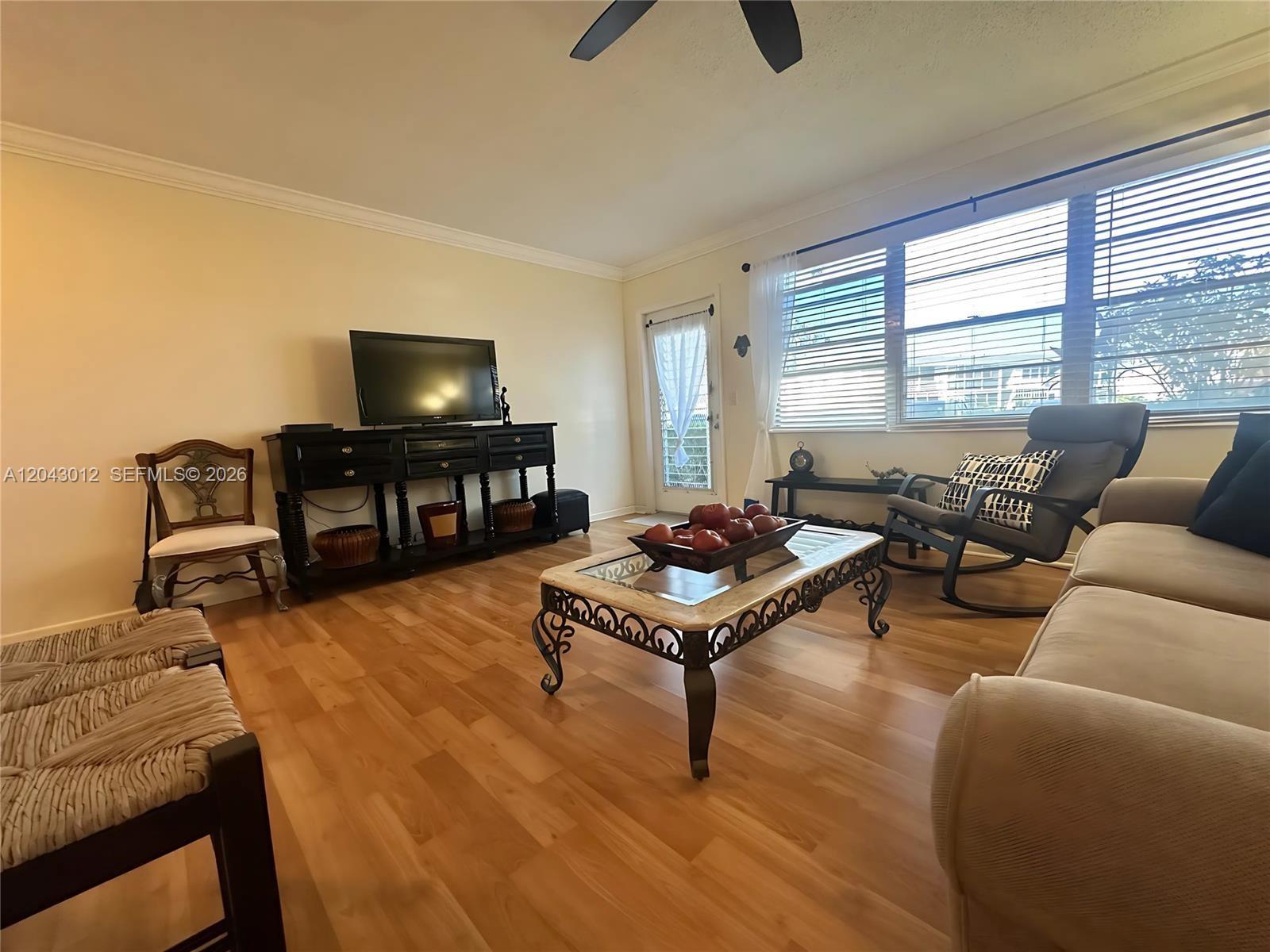 A living room features a television console, a coffee table, and a rocking chair — 1009 Harwood C # 1009, Deerfield Beach FL 33442, DEERFIELD BEACH, FL