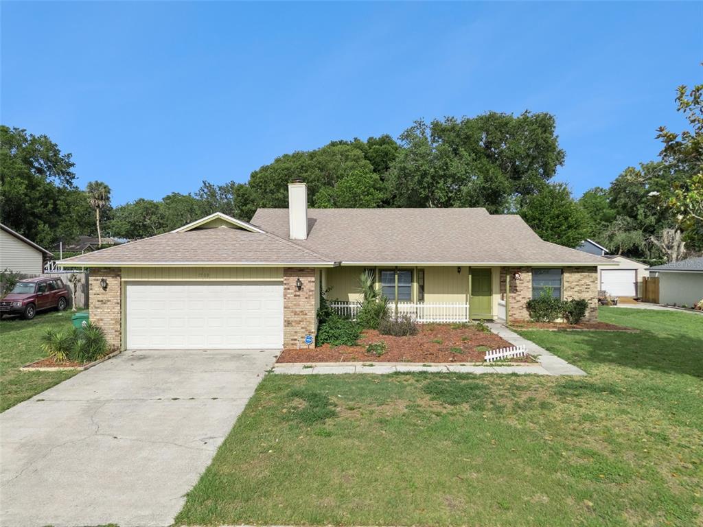 A single-story house with a brick and siding exterior, a two-car garage, and a chimney — 1503 COLUSO DRIVE, WINTER GARDEN, FL