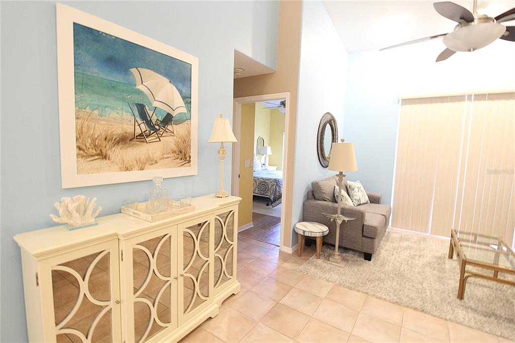 A living room features light blue walls, a white mirrored console, and a gray armchair — 4260 CENTRAL SARASOTA PARKWAY UNIT 224, SARASOTA, FL