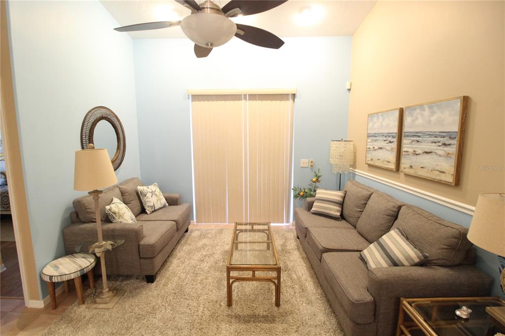 A living room features two gray sofas, a glass coffee table, and a ceiling fan — 4260 CENTRAL SARASOTA PARKWAY UNIT 224, SARASOTA, FL