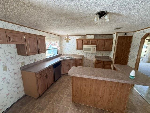 A kitchen features wood cabinets, floral wallpaper, a peninsula, and a double-basin sink — 18627 NW 24TH AVENUE, CITRA, FL