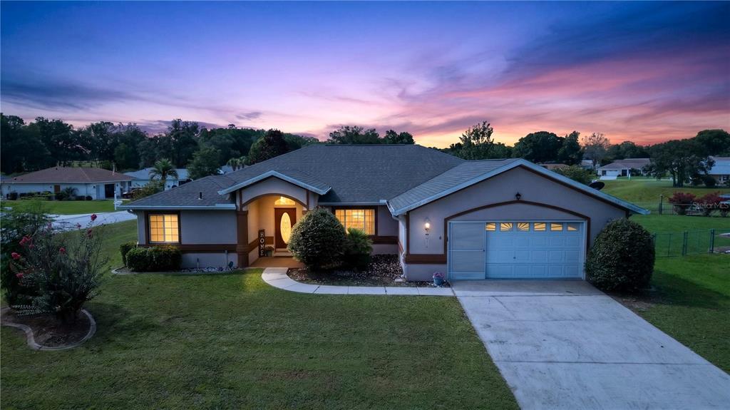 A single-story house with a garage and a front walkway at sunset — 10121 SW 61ST TERRACE ROAD, OCALA, FL