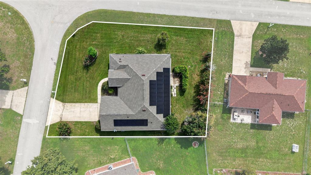An aerial view shows a house with solar panels on its roof and a fenced yard — 10121 SW 61ST TERRACE ROAD, OCALA, FL