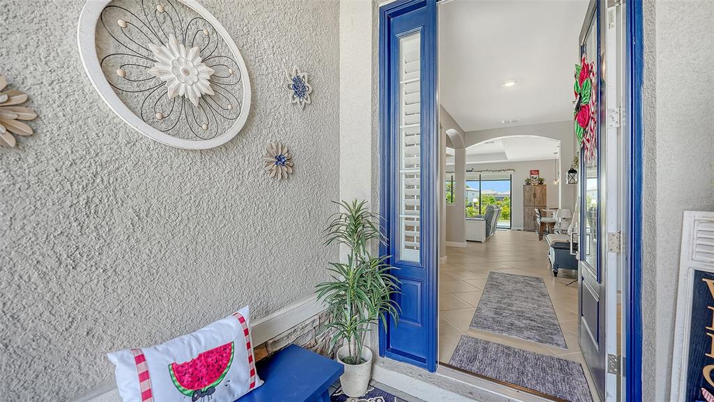 A view from a front porch looking through an open blue door into a home — 4971 OYSTER PEARL STREET, BRADENTON, FL