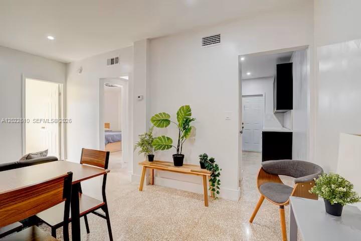 A dining area features a wooden table, chairs, potted plants, and doorways leading to other rooms — 224 NE 111th St, Miami FL 33161, MIAMI, FL