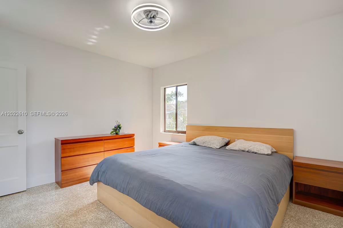 A bedroom features a bed with a wooden headboard, two nightstands, and a wooden dresser — 224 NE 111th St, Miami FL 33161, MIAMI, FL