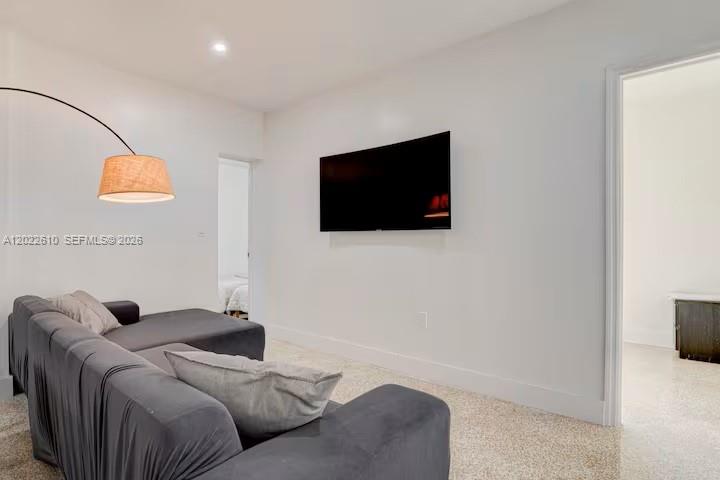 A living room features a grey sectional sofa, a wall-mounted television, and a floor lamp — 224 NE 111th St, Miami FL 33161, MIAMI, FL