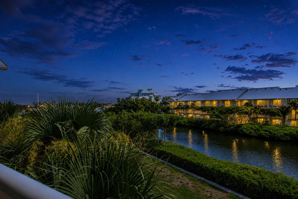A view of a canal and apartment buildings at dusk under a starry sky — 3273 MANGROVE POINT DRIVE, RUSKIN, FL