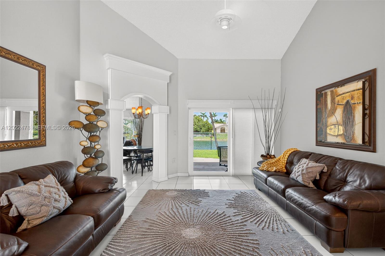 A living room with two brown leather sofas, a patterned rug, and a sliding door — 15891 SW 84th St, Miami FL 33193, MIAMI, FL