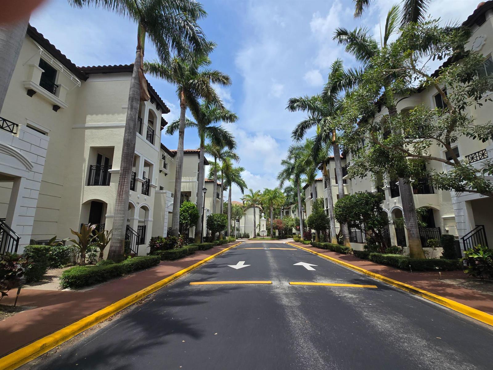 A paved road lined with palm trees runs between two multi-story residential apartment buildings — 1602 Coastal Bay Boulevard, Boynton Beach FL 33435, BOYNTON BEACH, FL