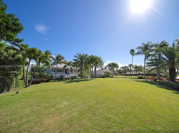 A large grassy lawn is surrounded by palm trees and houses under a sunny sky — 17433 SE Indian Hills Dr # 17433, Jupiter FL 33469, JUPITER, FL