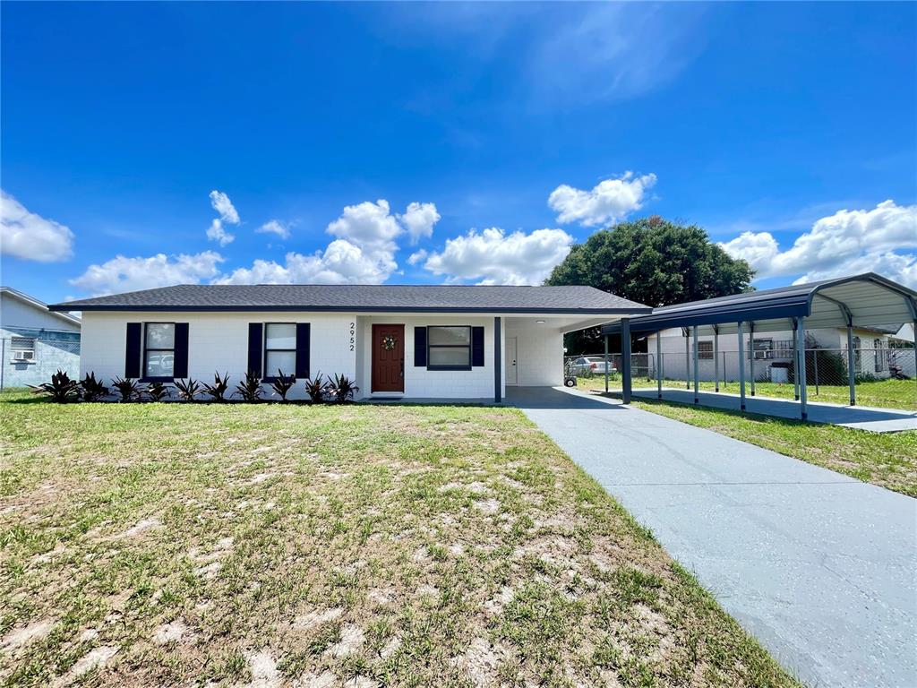 A white single-story house features a front porch, a carport, and black window shutters — 2952 MORRIS DRIVE, BARTOW, FL