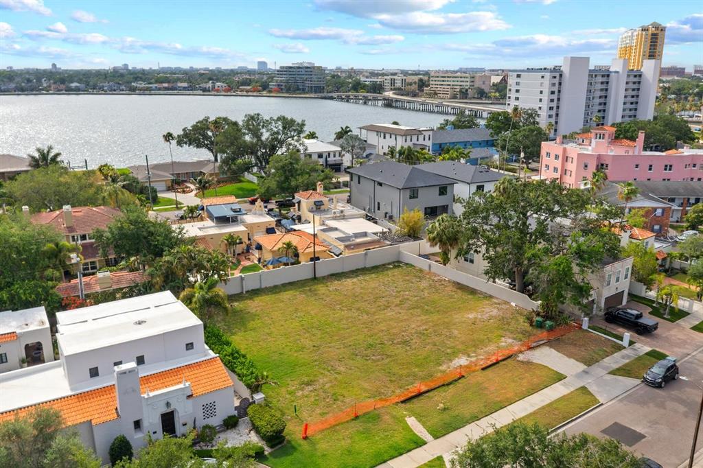 An aerial view shows a vacant rectangular lot situated in a residential neighborhood near water — 32 AEGEAN AVENUE, TAMPA, FL