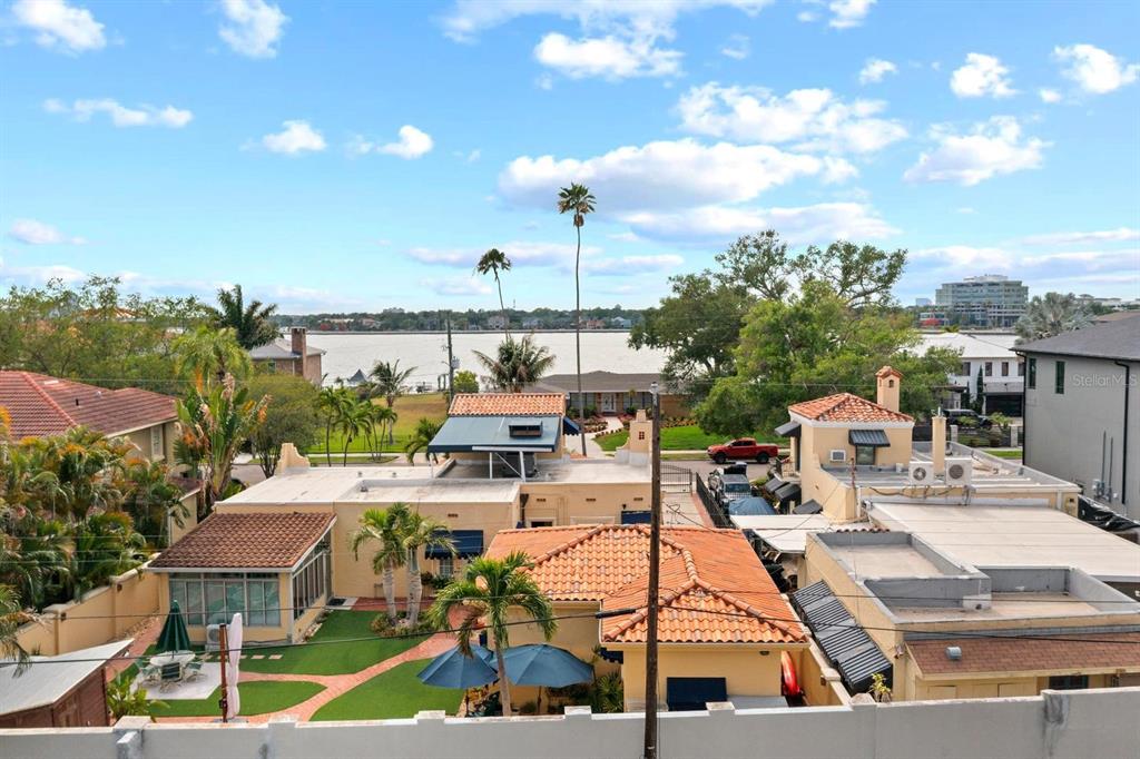 An elevated view of a residential neighborhood with terracotta-roofed houses near a body of water — 32 AEGEAN AVENUE, TAMPA, FL