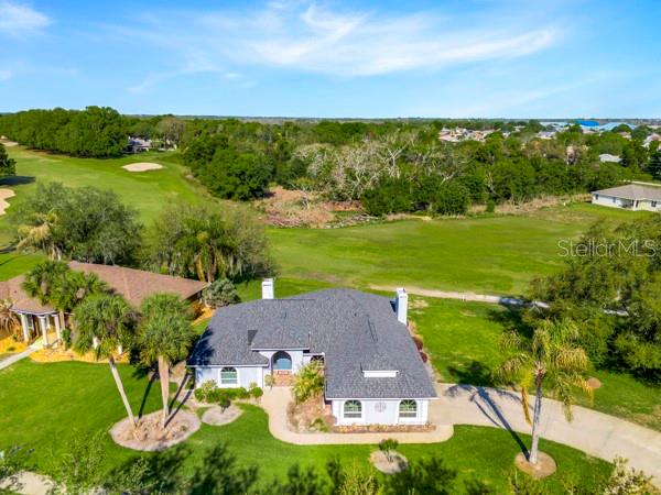 An aerial view shows a single-story house with a gray roof surrounded by green lawns — 8739 AUGUSTA CT COURT, CLERMONT, FL