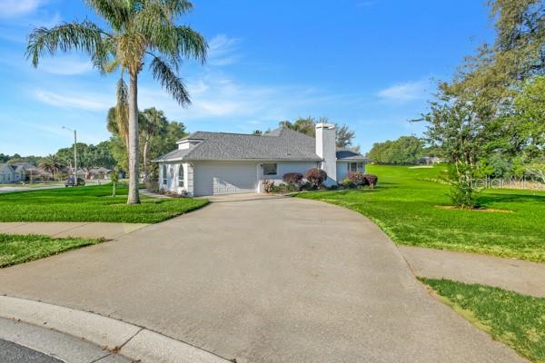 A single-story house with a gray roof and a concrete driveway sits on a lawn — 8739 AUGUSTA CT COURT, CLERMONT, FL