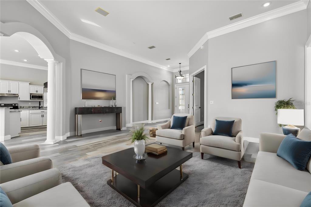 A living room features light gray walls, a dark coffee table, and two armchairs — 6644 COUNTRY CLUB ROAD, WESLEY CHAPEL, FL
