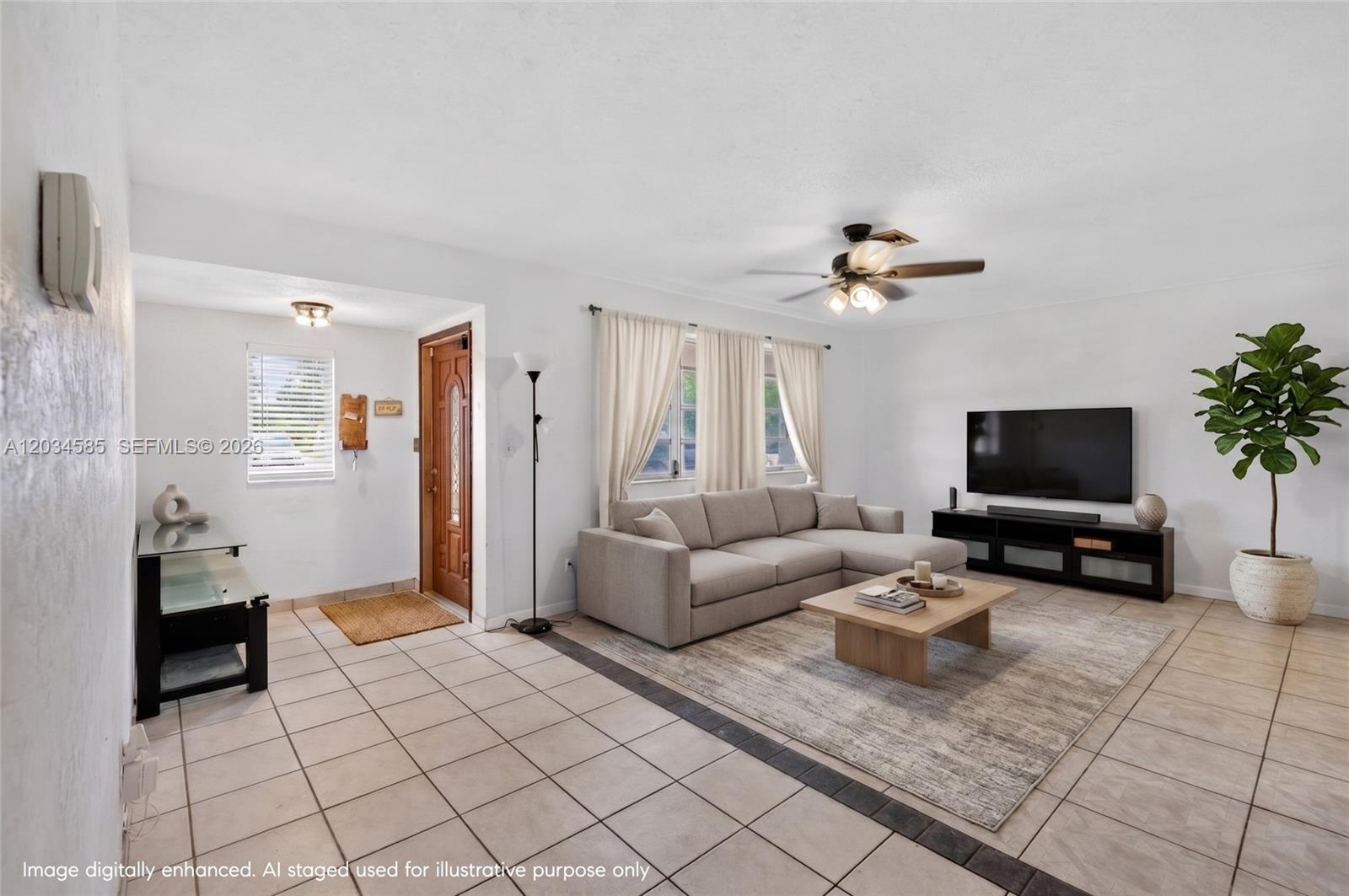 A living room features a sectional sofa, a television on a console, and tiled flooring — 1901 N 56th Ave, Hollywood FL 33021, HOLLYWOOD, FL
