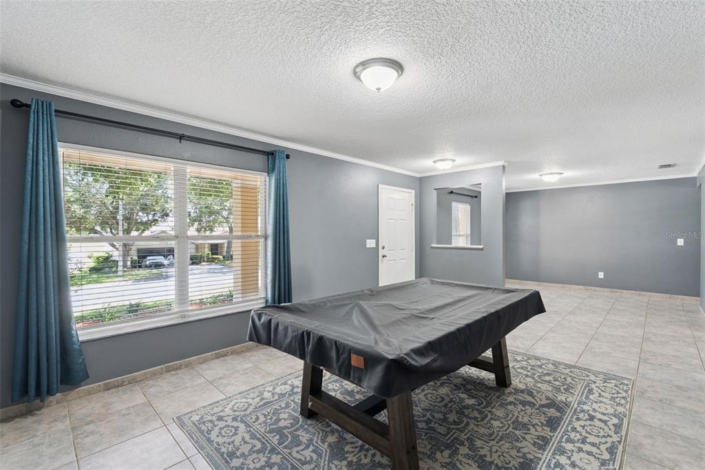 A game room features a pool table, tiled floors, gray walls, and a white door — 1804 VALE DRIVE, CLERMONT, FL