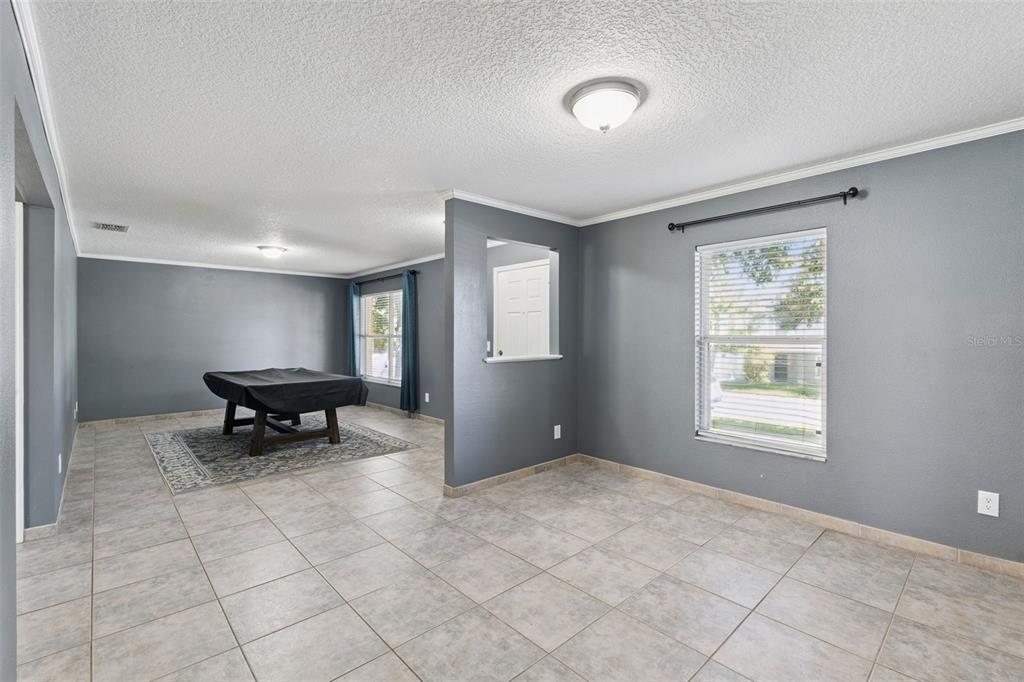 A dining room features a wooden table, six upholstered chairs, and gray walls — 1804 VALE DRIVE, CLERMONT, FL