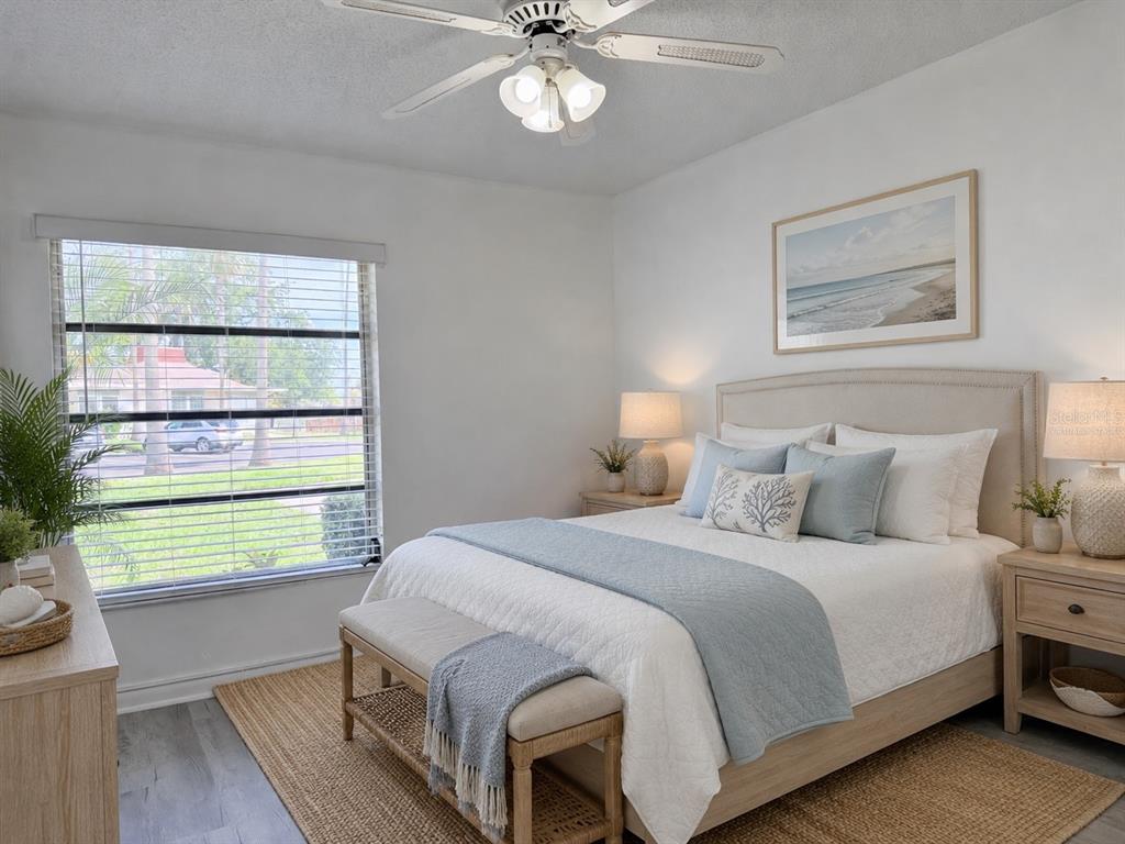 A bedroom features a queen bed, a bench, a ceiling fan, and a large window — 4313 TAHITIAN GARDENS CIRCLE UNIT C, HOLIDAY, FL