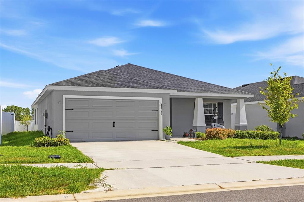 A single-story gray house with a two-car garage and a concrete driveway — 2156 DESERT ROSE DRIVE, DAVENPORT, FL