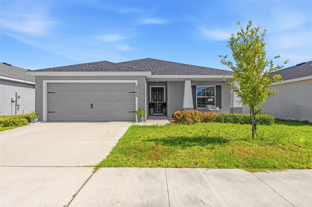 A single-story gray house with a two-car garage and a front lawn — 2156 DESERT ROSE DRIVE, DAVENPORT, FL