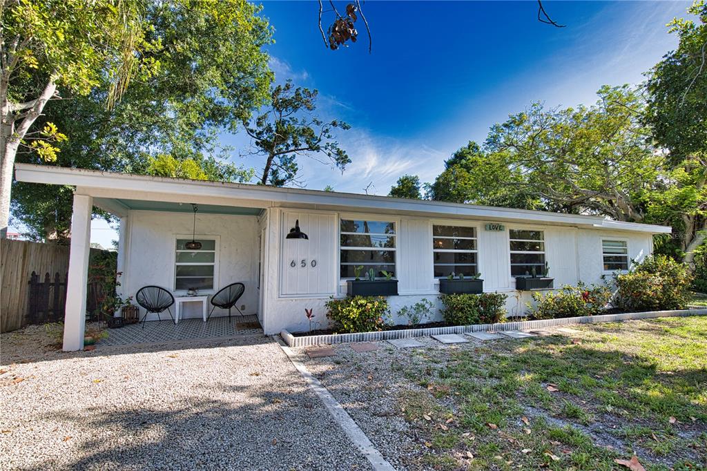A single-story white house with a gravel driveway, covered porch, and three front windows — 650 EDWARDS STREET, ENGLEWOOD, FL